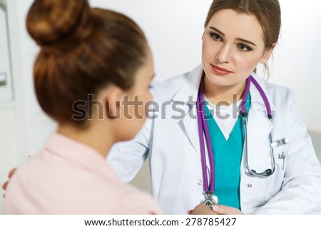 Beautiful female doctor holding patient\'s hand for encouragement and empathy and touching her arm. Partnership, trust and medical ethics concept. Bad news lessening and support. Patient cheering