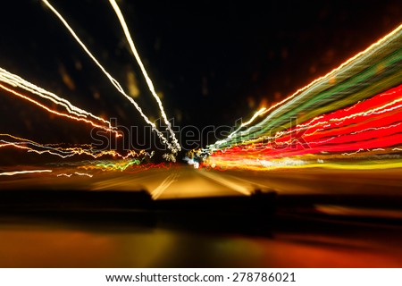 Drunken driving concept. Speedy night driving. Sleepy driver looking on night road. Drugs and alcohol effect. Blurry and blending road during high speed trip.
