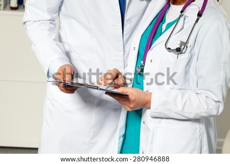 Two medicine doctors examining patient documents and tests. Professional conversation, council of physicians. Working conference of colleagues. Medical consultation concept of heart disease treatment