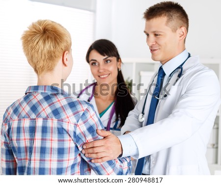 Male doctor shaking hands with female patient and touching her arm. Partnership, trust and medical ethics concept. Handshake with satisfied client. Thankful handclasp for excellent treatment.