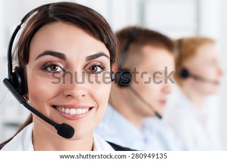 Three call center service operators at work. Portrait of smiling pretty female helpdesk employee with headset at workplace. Effective and efficient business information, help and support concept