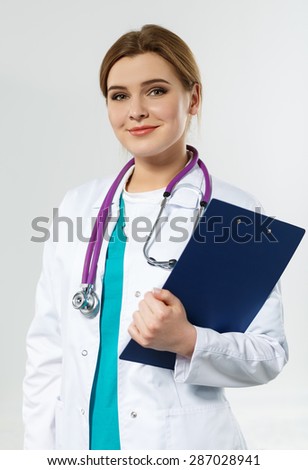 Beautiful smiling female medicine doctor holding clipped document pad. Medical help or insurance concept. Doctor is waiting for patient to examine. Physician reception concept
