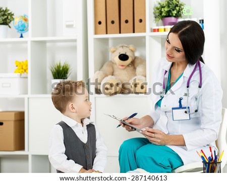 Family doctor examination. Little child visiting pediatrician playing. Beautiful female medical doctor with freckles communicating with cute young patient. Paediatrics medical concept