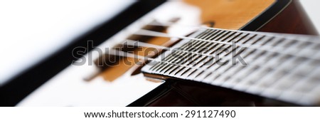 Small Hawaiian four stringed ukulele guitar body closeup letterbox view. Musical instruments shop or learning school concept