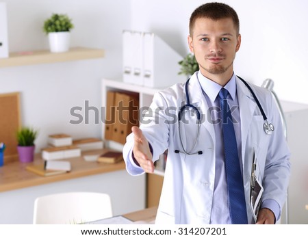 Male medicine doctor offering hand to shake in office. Greeting and welcoming gesture. Medical cure and tests advertisement concept. Physician ready to examine patient