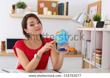 Young beautiful female student pointing something on globe. Geography, politics, culture or history lesson concept. Education, studying, learning, teaching, self development and perfection concept