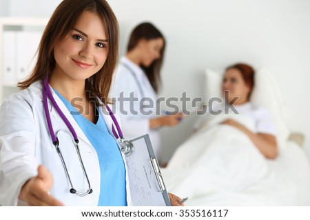 Female medicine doctor offering hand to shake while patient lying in bed communicating with doctor during ward round. Greeting and welcoming gesture. Medical cure and tests advertisement concept