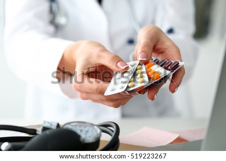 Female doctor hand holding pack of different tablet blisters at workplace closeup. Panacea, life save service, prescribe medicament, legal drug store, disease healing, blood pressure concept