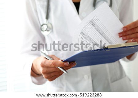 Female medicine doctor hand holding silver pen looking in clipboard pad closeup. Ward round, patient visit check, 911, medical calculation and statistics concept. Physician ready to examine patient