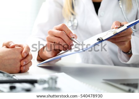 Female doctor hand hold silver pen filling patient history list at clipboard pad. Physical, exam, er, disease prevention, ward round, visit check, 911, prescribe remedy, healthy lifestyle concept