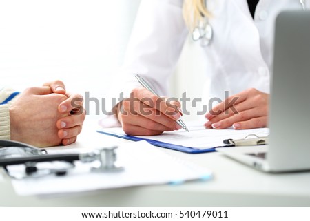 Female doctor hand hold silver pen filling patient history list at clipboard pad. Physical, exam, er, disease prevention, ward round, visit check, 911, prescribe remedy, healthy lifestyle concept