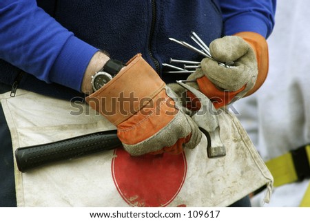 Gloved Hands Filling Work Apron With Nails