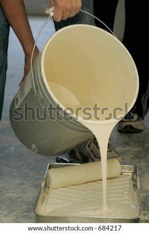hands pouring paint from a large bucket