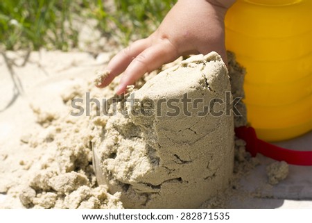 child plays builds towers of sand