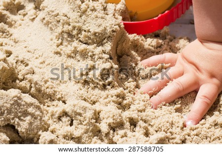 child plays builds towers of sand