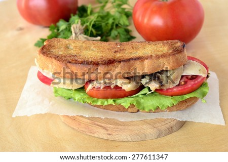 Sandwich with chicken and vegetables on a rustic wooden board