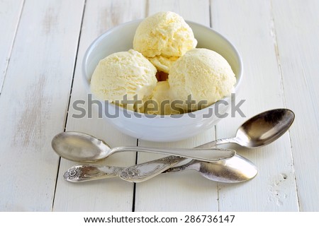 Vanilla ice cream in white bowl on wooden background