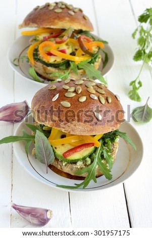 Wholegrain burger with fresh vegetables on a wooden background, vegetarian, vertical