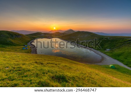 sunset viewed from the top of the mountain overlooking a mountain lake