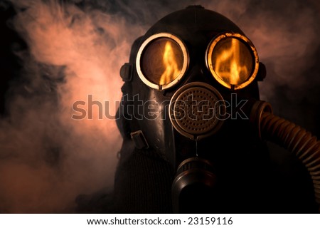 Man in gas mask with fire reflection in the eyes
