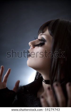 Expressive young woman with creative make-up and big feather artificial eyelashes, soft focus