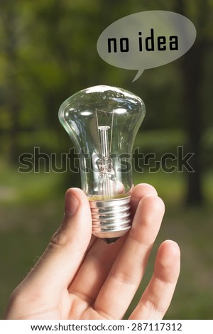 lamp in male hands on a green background with the words 