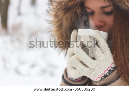 Beautiful Happy Smiling Winter Woman with Mug Outdoor. Smiling Girl Outdoors with Hot Drink