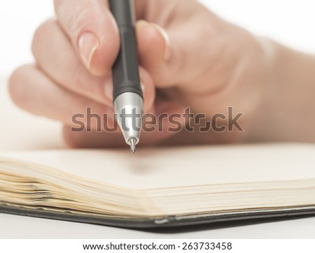 Female hand writing in notebook, isolated on white