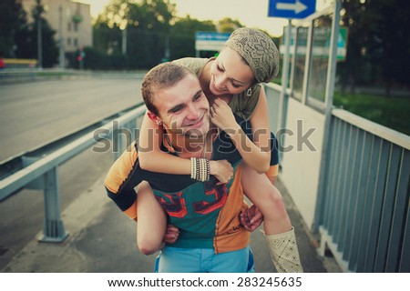 Young man carrying his girlfriend on the back in the park