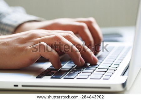 Office man hand on laptop keyboard