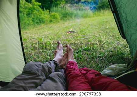 Legs of two people can be seen from the tourist tents