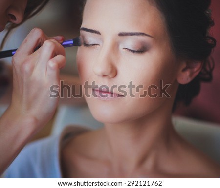 a girl is having her make up done