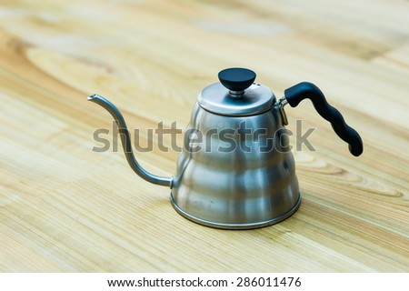Steel tea kettle on wooden table