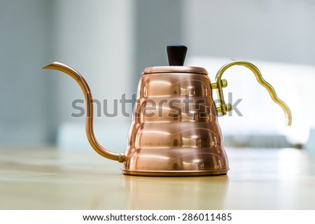 Steel tea kettle on wooden table