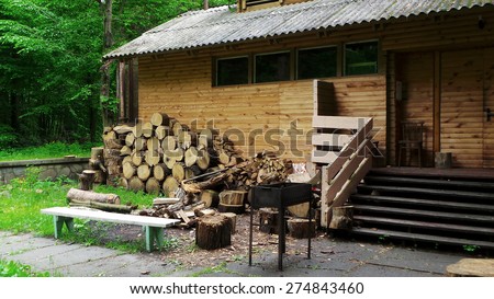 Country cottage with barbecue grill and firewood ready to picnic