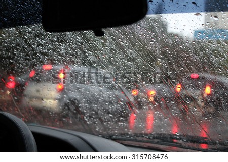 Look on wet city through windshield from inside the car at rain weather