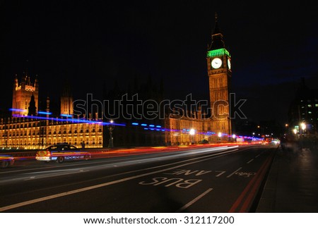 Big Ben and Westminster Abbey at night with police cars driving passed/ London Big Ben at night