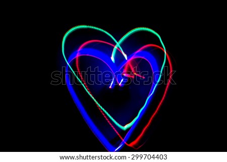 Light of painting the heart shape on black background.