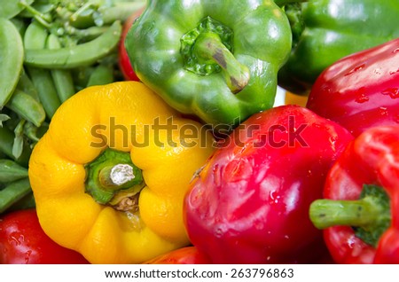 Ripe Yellow, Red and Green Peppers in Vegetables Market