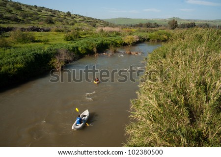 JORDAN RIVER, ISRAEL - APRIL 2: After a season of record rainfall, youth paddle rafts down the muddy brown waters of the Jordan River toward the Sea of Galilee in northern Israel on April 2, 2012.