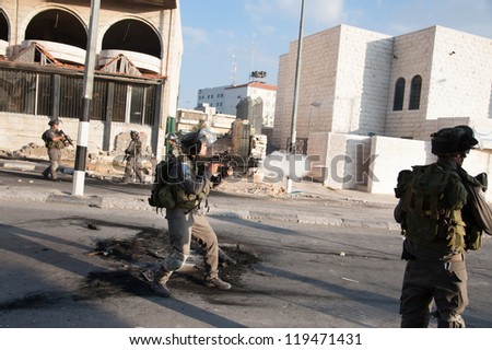BETHLEHEM, PALESTINIAN TERRITORY - NOVEMBER 20: An Israeli soldier fires a tear gas grenade in the West Bank town of Bethlehem during clashes protesting Israel\'s attacks on Gaza, November 20, 2012.