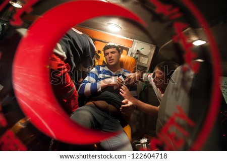 BETHLEHEM, PALESTINIAN TERRITORY - NOVEMBER 15: Emergency medical workers treat a Palestinian youth shot with a rubber-coated steel bullet by Israeli forces during a demonstration, November 15, 2012.