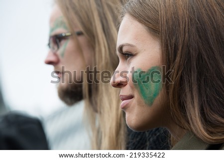 OSLO - SEPTEMBER 21: A woman and man with green hearts painted on their faces join thousands marching through downtown Oslo, Norway, to support action on global climate change, September 21, 2014.