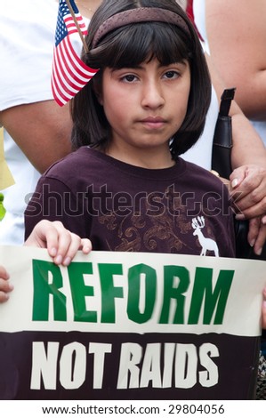 WASHINGTON, DC - MAY 1: A young girl carries a sign with immigrants and their supporters march to the White House to call for legal reforms and an end to workplace raids May 1, 2009 in Washington, DC.