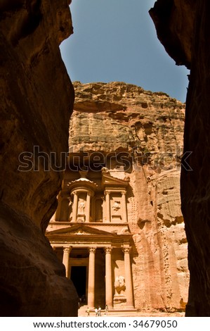 The Treasury seen through the Siq, a narrow canyon path through high rock cliffs, at Petra, Jordan.