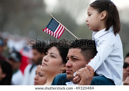 WASHINGTON, DC - MARCH 21: A girl and her father stand with some 200,000 immigrants\' rights activists flood the National Mall  to demand comprehensive immigration reform on March 21, 2010 in Washington DC.