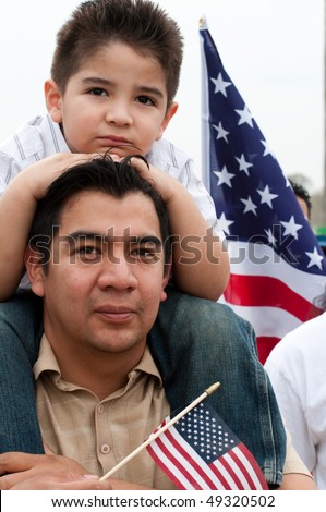 WASHINGTON, DC - MARCH 21: A boy on his father\'s shoulders stands with some 200,000 immigrants\' rights activists flood the National Mall to demand comprehensive immigration reform on March 21, 2010 in Washington DC.