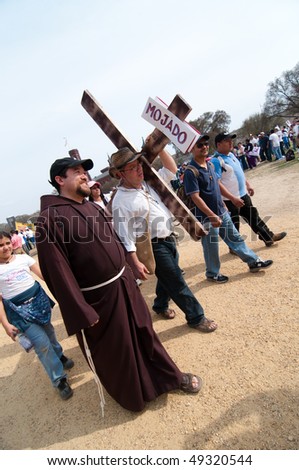 WASHINGTON, DC - MARCH 21: A robed Benedictine priest walks with a man carrying a cross among some 200,000 immigrants\' rights activists rallying on the National Mall on March 21, 2010 in Washington DC.