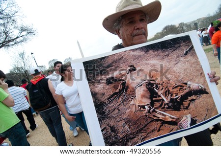 WASHINGTON, DC - MARCH 21: A man carries the photo of an immigrant border death while marching with some 200,000 immigrants\' rights activists on the National Mall on March 21, 2010 in Washington DC.