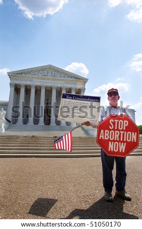 WASHINGTON, DC - MAY 14: An anti-abortion protester holds a stop sign and the Ten Commandments on the sidewalk in front of the U.S. Supreme Court on May 14, 2001 in Washington, D.C.